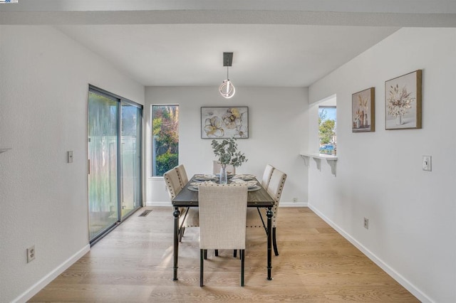 dining space with a healthy amount of sunlight and light hardwood / wood-style flooring