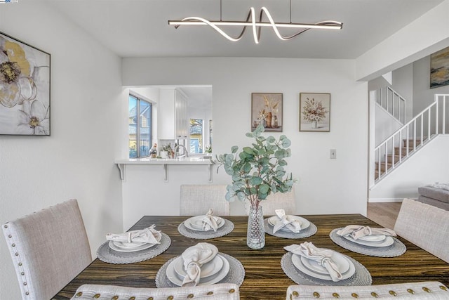 dining space featuring wood-type flooring and a notable chandelier