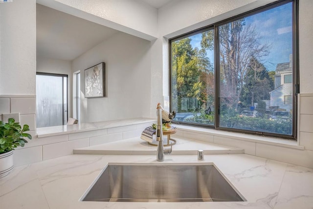 kitchen featuring light stone counters and sink