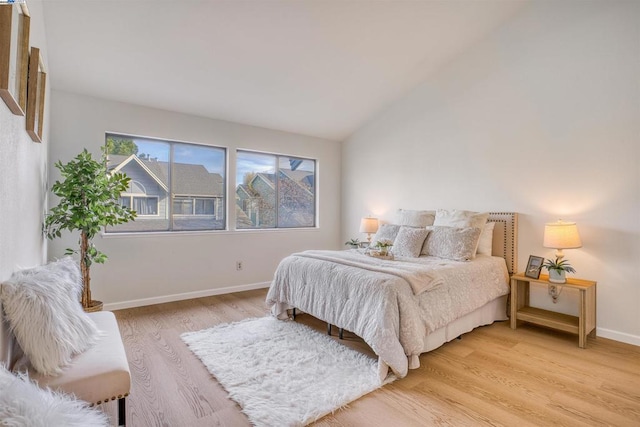 bedroom with light hardwood / wood-style floors and vaulted ceiling