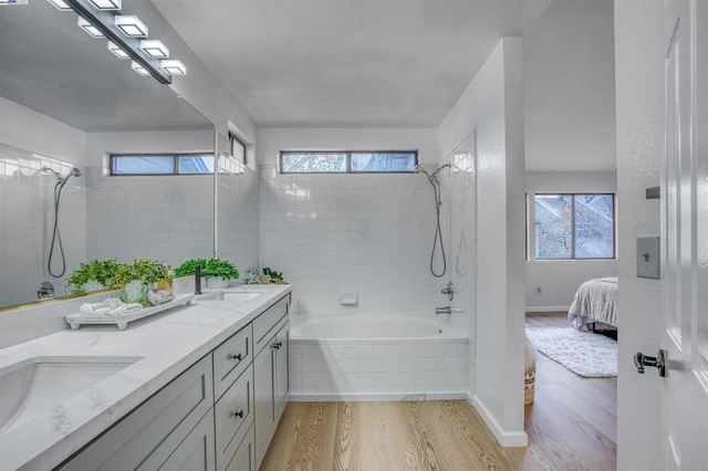 bathroom featuring hardwood / wood-style floors, tiled shower / bath combo, and vanity