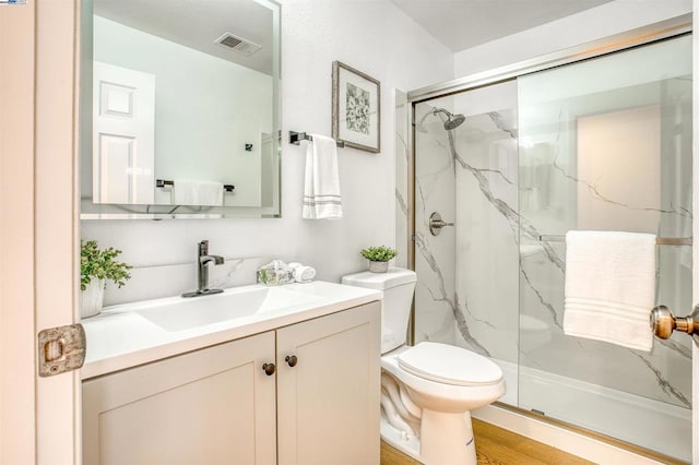 bathroom with toilet, hardwood / wood-style floors, tasteful backsplash, an enclosed shower, and vanity