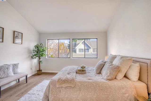 bedroom featuring lofted ceiling and light wood-type flooring