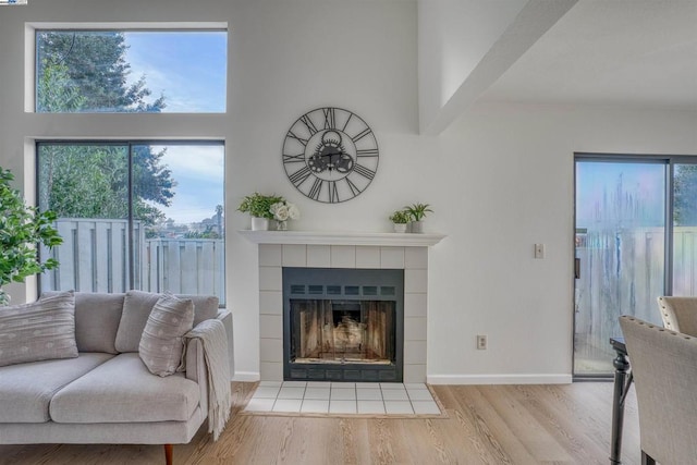 living room featuring a tile fireplace and light hardwood / wood-style floors