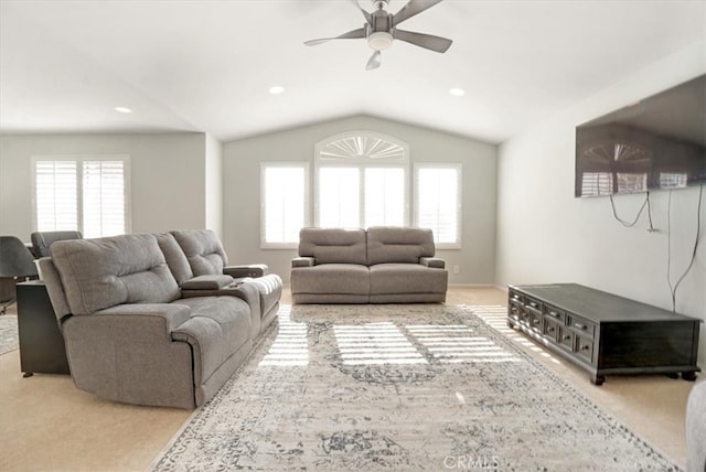 carpeted living room with ceiling fan and vaulted ceiling