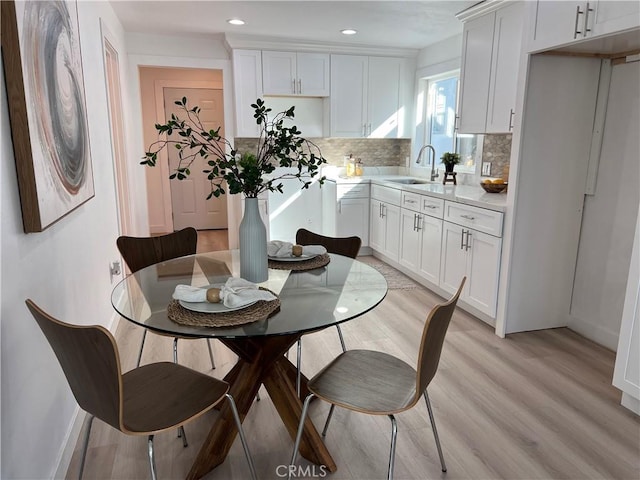 dining space featuring sink and light wood-type flooring