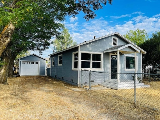 view of front of home featuring a garage and an outbuilding