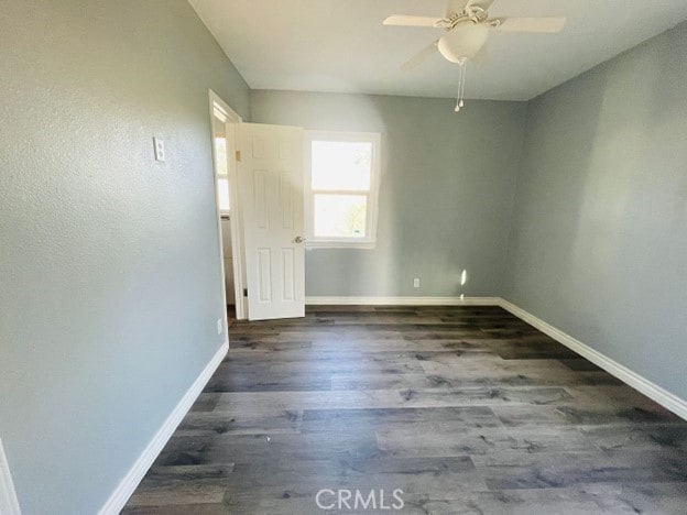 unfurnished room with ceiling fan and dark hardwood / wood-style floors