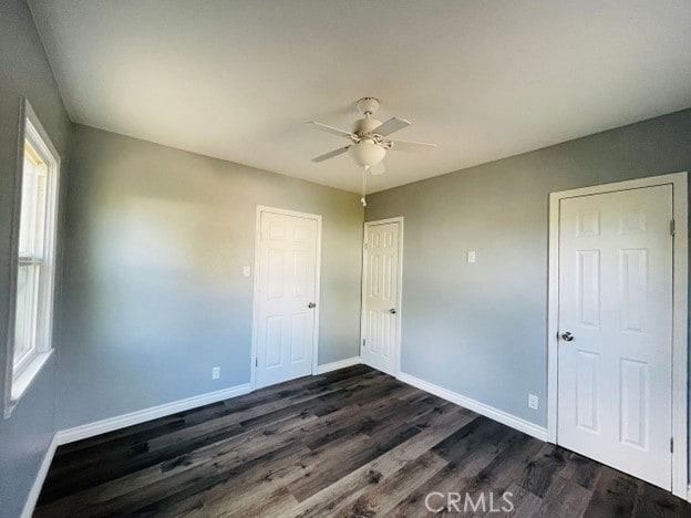 unfurnished bedroom featuring ceiling fan and dark hardwood / wood-style floors