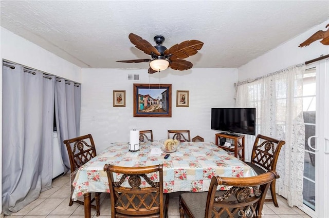 tiled dining area featuring ceiling fan and a textured ceiling