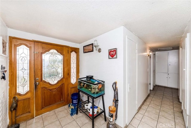 tiled foyer entrance with a textured ceiling