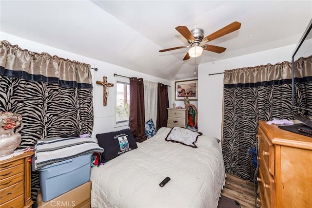 bedroom with ceiling fan, wood-type flooring, and lofted ceiling