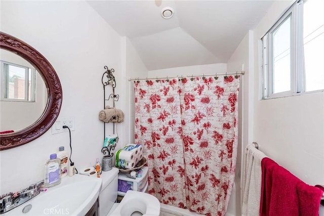 bathroom featuring lofted ceiling and a shower with curtain