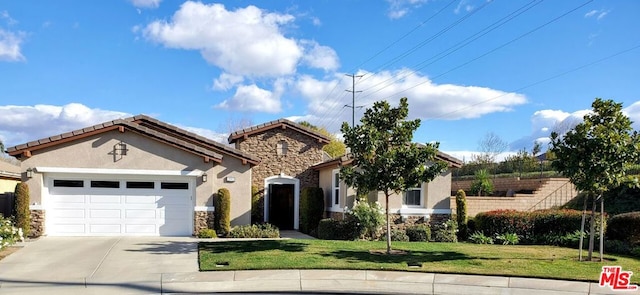 mediterranean / spanish home with a garage and a front yard