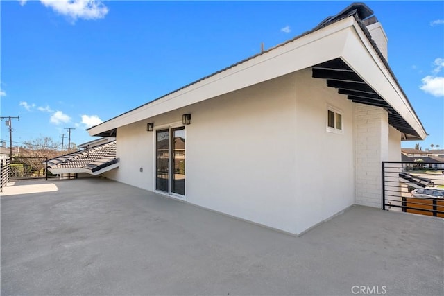 view of property exterior with a patio area