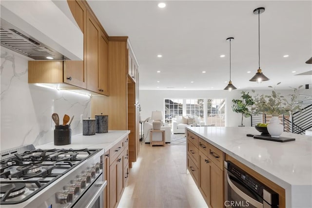 kitchen featuring premium range hood, stainless steel range, backsplash, light wood-type flooring, and pendant lighting