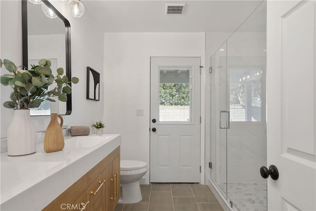 bathroom featuring an enclosed shower, vanity, tile patterned floors, and toilet