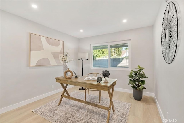 home office with light hardwood / wood-style flooring