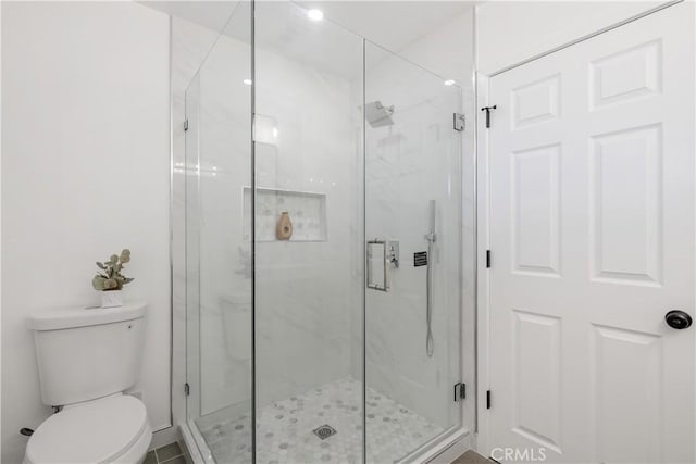 bathroom featuring an enclosed shower and toilet