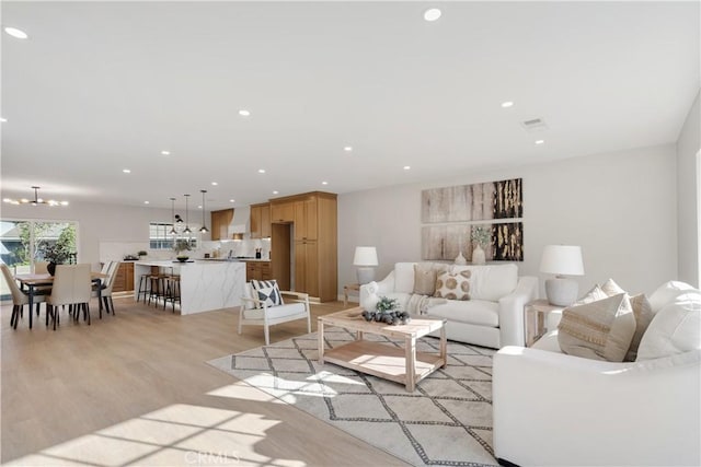 living room featuring an inviting chandelier and light hardwood / wood-style floors