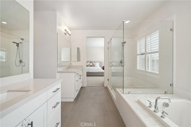 bathroom with vanity and shower with separate bathtub