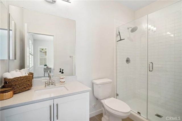 bathroom with an enclosed shower, vanity, and toilet