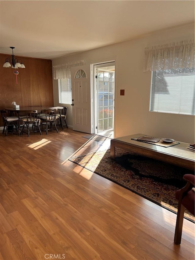 entrance foyer with hardwood / wood-style flooring, a chandelier, and wood walls