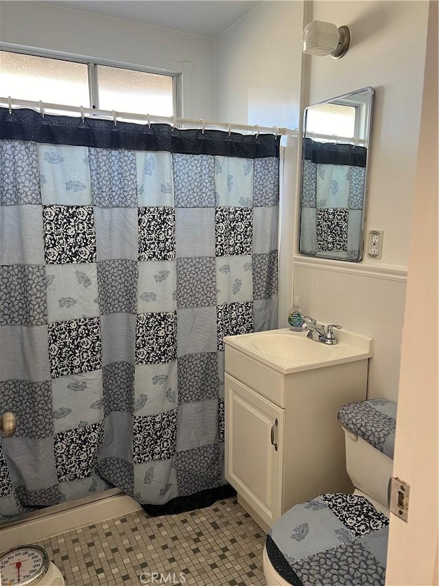 bathroom with vanity, tile patterned flooring, toilet, and walk in shower