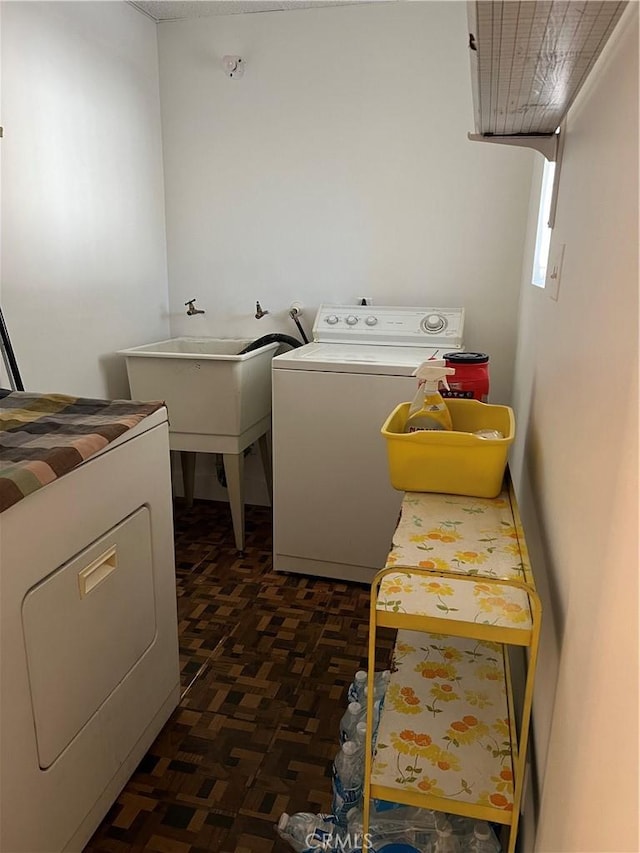 laundry area with separate washer and dryer and sink