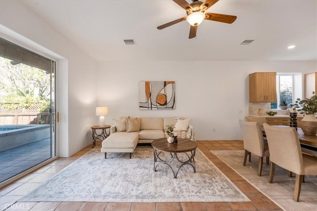 living room featuring light tile patterned floors, plenty of natural light, and ceiling fan