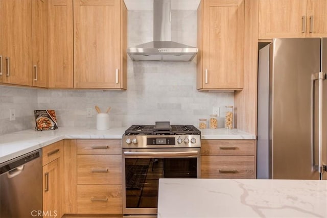 kitchen featuring stainless steel appliances, wall chimney range hood, backsplash, and light brown cabinetry