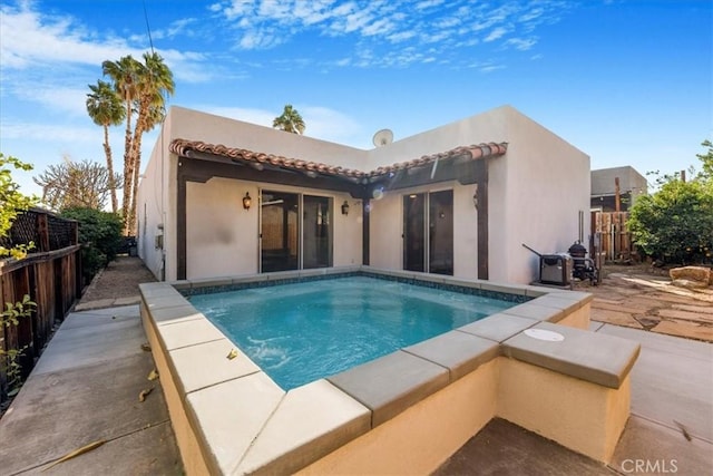 rear view of house featuring a fenced in pool