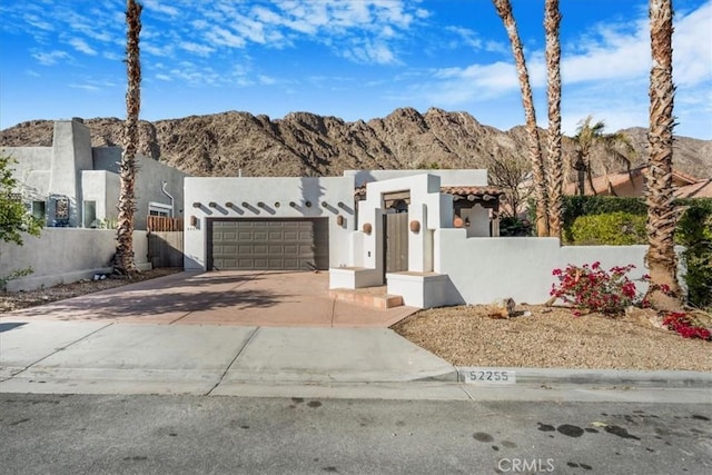 adobe home featuring a garage and a mountain view