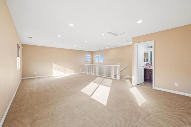 spare room with light carpet, recessed lighting, and baseboards