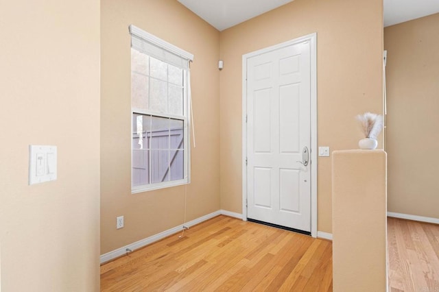 foyer with light wood-style floors and baseboards