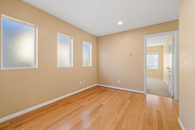 spare room with recessed lighting, light wood-type flooring, and baseboards