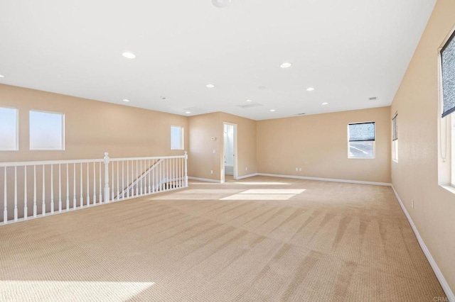 unfurnished room with light carpet, baseboards, a wealth of natural light, and recessed lighting