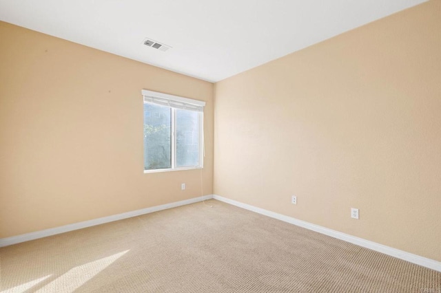 carpeted empty room with visible vents and baseboards