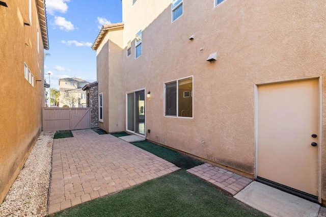 back of house featuring a patio, fence, a tiled roof, and stucco siding