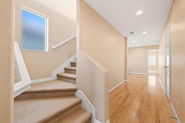 staircase featuring visible vents, baseboards, wood finished floors, and recessed lighting