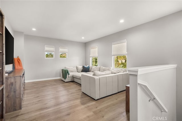 living room featuring a healthy amount of sunlight and light hardwood / wood-style flooring