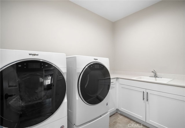 laundry area featuring washer and dryer, light tile patterned floors, sink, and cabinets