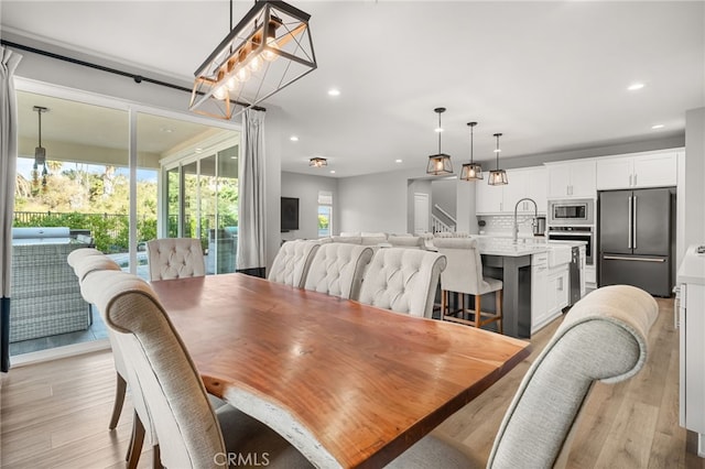 dining space with light hardwood / wood-style floors and sink