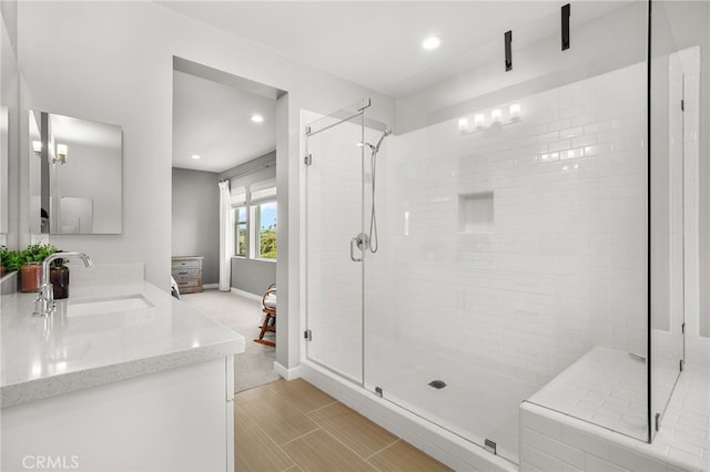 bathroom with walk in shower and vanity