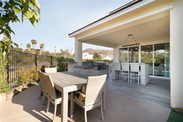 view of patio with area for grilling, exterior kitchen, and an outdoor bar