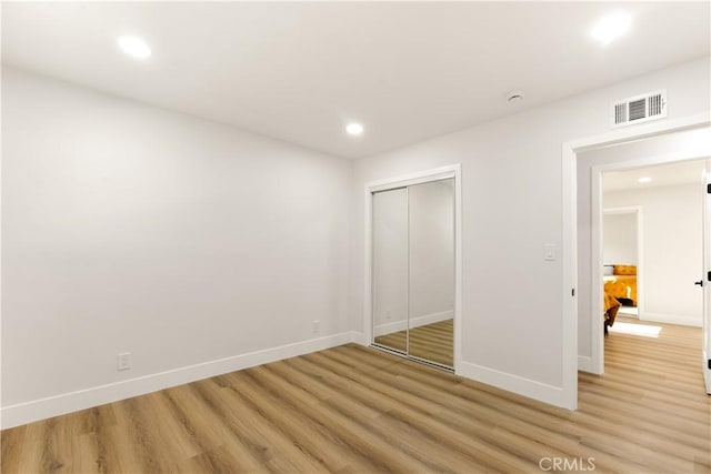 unfurnished bedroom featuring light wood-type flooring and a closet