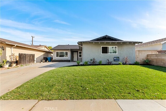 single story home featuring a front lawn