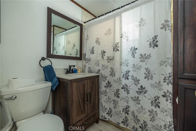 bathroom with hardwood / wood-style flooring, toilet, and vanity