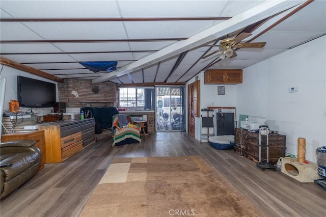 living room with ceiling fan, dark hardwood / wood-style floors, and vaulted ceiling