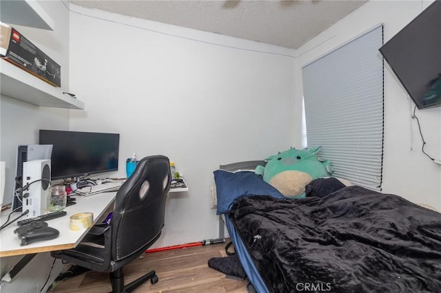 bedroom with a textured ceiling and hardwood / wood-style floors